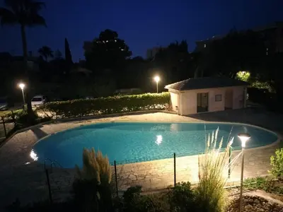 a swimming pool in a yard at night at Lovely Studio & Garden - près des plages Cagnes-sur-Mer in Cagnes-sur-Mer