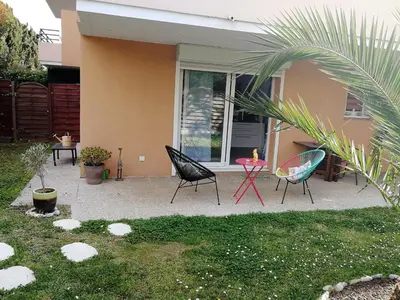a patio with chairs and a table in front of a house at Lovely Studio & Garden - près des plages Cagnes-sur-Mer in Cagnes-sur-Mer