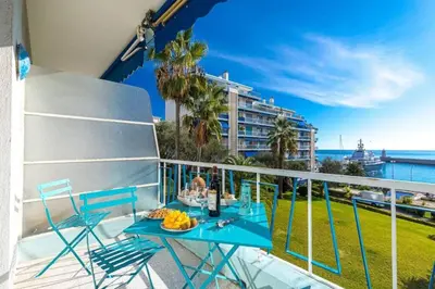a blue table on a balcony with a view of the ocean at MY CASA - FRANCK PILATTE - Beautiful Sea View - Near the Port in Nice