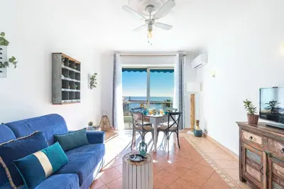 a living room with a blue couch and a table at MY CASA - FRANCK PILATTE - Beautiful Sea View - Near the Port in Nice