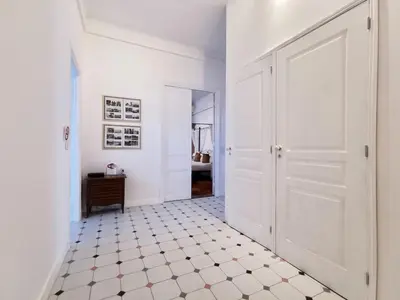 a hallway with a white door and a tiled floor at Congrès Carré d'Or by Booking Guys in Nice