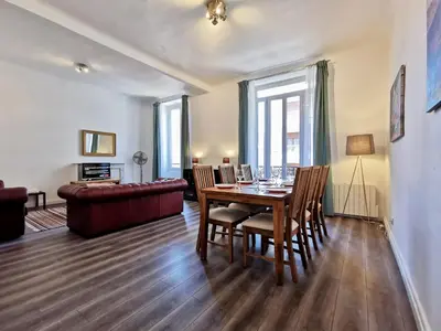a living room with a table and chairs and a couch at Congrès Carré d'Or by Booking Guys in Nice