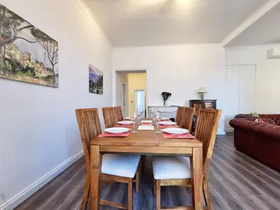 a dining room with a wooden table and chairs at Congrès Carré d'Or by Booking Guys in Nice