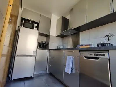 a kitchen with stainless steel appliances and a white refrigerator at Legion Suite - Your perfect vacation ! in Nice