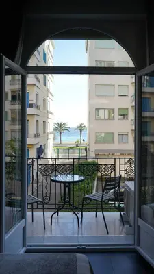 a patio with a table and chairs on a balcony at Cozy studio with a sea view in Nice