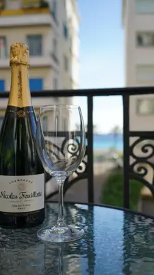 a bottle of champagne and a wine glass on a table at Cozy studio with a sea view in Nice