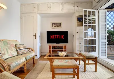 a living room with a couch and a tv at Nestor&Jeeves - BEACH COTTAGE TERRACE - Central - Very close sea - Top floor in Nice