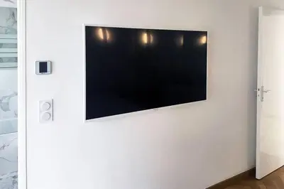 a flat screen tv hanging on a white wall at Promenade des anglais Amazing sea view 140M2 3BR in Nice