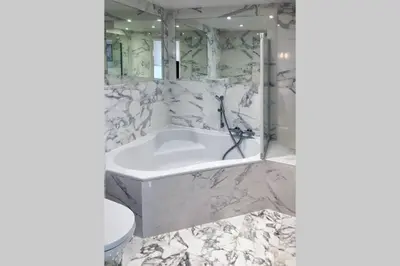 a white bathroom with a tub and a toilet at Promenade des anglais Amazing sea view 140M2 3BR in Nice