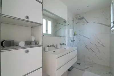 a white bathroom with a sink and a mirror at Appartement Mera Cosy apartment with incredible sea view in Èze