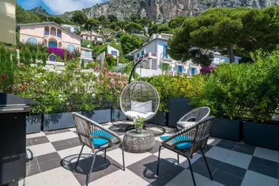 a patio with chairs and a table with a view at Appartement Mera Cosy apartment with incredible sea view in Èze