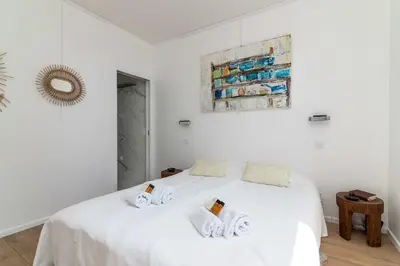 a bedroom with a white bed with towels on it at Appartement Mera Cosy apartment with incredible sea view in Èze