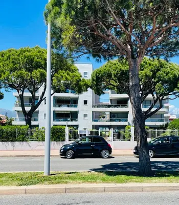 a car parked in a parking lot next to a tree at Cocon douillet face à la mer de Cagnes sur mer in Cagnes-sur-Mer