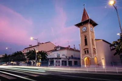 a building with a clock tower on a street at Cocon douillet face à la mer de Cagnes sur mer in Cagnes-sur-Mer