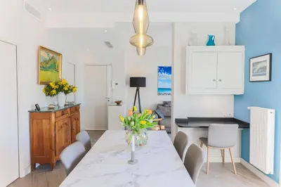 a dining room with a table with a vase of flowers on it at La Terrasse du Port AP4212 in Nice