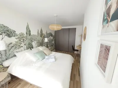 a bedroom with a white bed and plants on the wall at Sunny and calm 2 bed apartment place du Pin in Nice