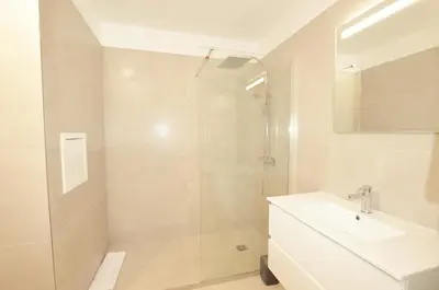 a white bathroom with a shower and a sink at La Perle d'Eze - Aparthotel in Èze