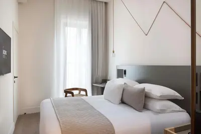 a bedroom with a bed and a tv on a wall at Ikonik Jean Médecin in Nice