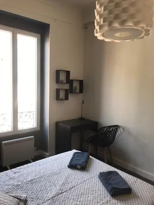 a bedroom with a bed and a chair and a window at Moderne, 2 chambres, 6 Couchages, EASY CHECK-IN in Nice