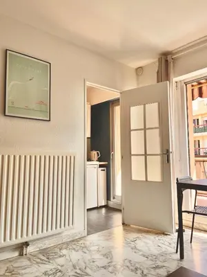 a white room with a door and a kitchen at Studio with terrace and sea view, 10 min to the beach in Nice