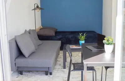 a living room with a couch and a table at Studio with terrace and sea view, 10 min to the beach in Nice