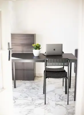 a desk with a laptop and a chair in a room at Studio with terrace and sea view, 10 min to the beach in Nice