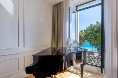 a black piano in a room with a large window at QUAI PROMENADE New Seafront Balcony Air Conditioning in Nice