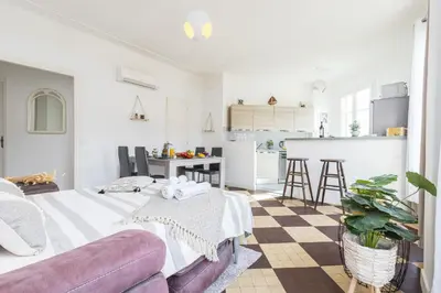 a living room with a couch and a kitchen at FEEL HOME - DE GAULLE - Villefranche-sur-Mer in Villefranche-sur-Mer
