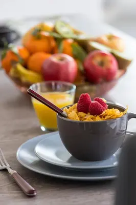 a bowl of cereal with berries on a table with a bowl of fruit at FEEL HOME - DE GAULLE - Villefranche-sur-Mer in Villefranche-sur-Mer