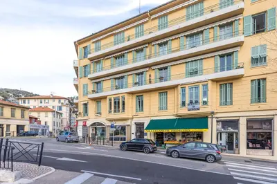 a building with cars parked in front of a street at FEEL HOME - DE GAULLE - Villefranche-sur-Mer in Villefranche-sur-Mer