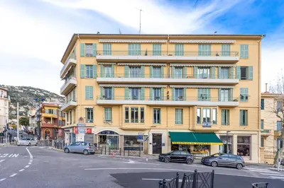 a large yellow building with cars parked in front of it at FEEL HOME - DE GAULLE - Villefranche-sur-Mer in Villefranche-sur-Mer