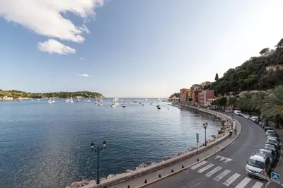 a street next to a body of water with boats at FEEL HOME - DE GAULLE - Villefranche-sur-Mer in Villefranche-sur-Mer