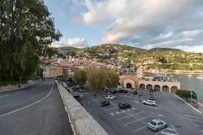 a city street with cars parked in a parking lot at FEEL HOME - DE GAULLE - Villefranche-sur-Mer in Villefranche-sur-Mer