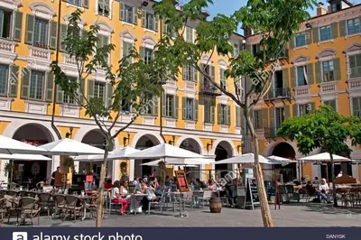 people sitting at tables under umbrellas in front of a building at Garibaldi 3 chambres 6 couchages, EASY CHECK-IN in Nice