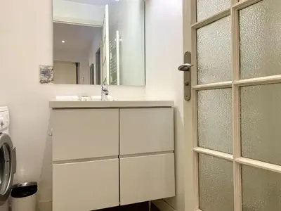 a white bathroom with a sink and a mirror at ApartHotel Riviera - 2 minutes de la plage - Exceptionnel 2 chambres AC - BALCON MEYERBEER 1 in Nice