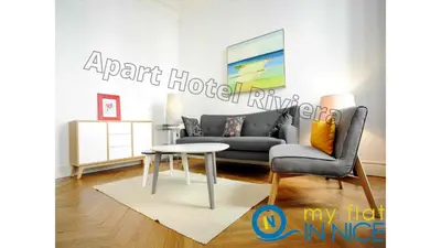 a living room with a couch and a table at ApartHotel Riviera - 2 minutes de la plage - Exceptionnel 2 chambres AC - BALCON MEYERBEER 1 in Nice
