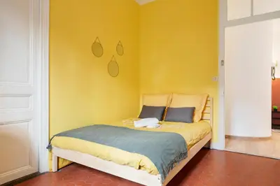 a bedroom with a bed with a yellow wall at Cosy and Trendy 3 Bedrooms train tramway in Nice