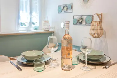 a bottle of wine sitting on a table with glasses at Studio climatisé à 50m des plages in Nice