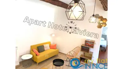 a living room with a yellow couch and a chandelier at ApartHotel Riviera - ISTRIA 1- Old town Promenade des Anglais - Superbe Appartement Superior 2 Pièces AC in Nice