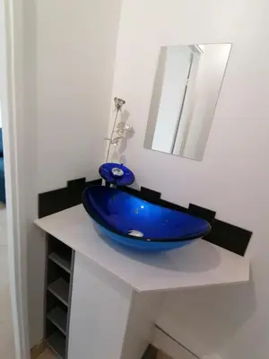 a blue bowl on a white counter with a mirror at Nice Vue Mer 50m plage Parking in Nice