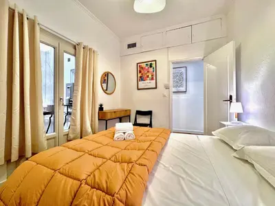 a bedroom with a large bed with an orange blanket at ApartHotel Riviera - Maison de la Poissonnerie - Vieille Ville - Grand Appartement 3 piece AC - 5min de la Promenade des Anglais in Nice