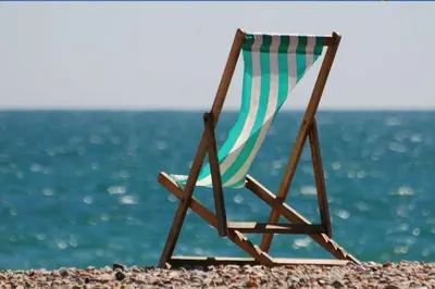 a beach chair sitting on the shore of the ocean at ApartHotel Riviera - Maison de la Poissonnerie - Vieille Ville - Grand Appartement 3 piece AC - 5min de la Promenade des Anglais in Nice