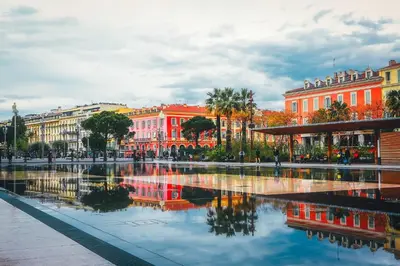 a city with buildings and a reflection in the water at ApartHotel Riviera - Maison de la Poissonnerie - Vieille Ville - Grand Appartement 3 piece AC - 5min de la Promenade des Anglais in Nice