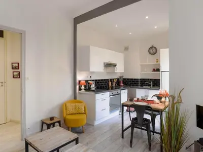 a kitchen with a table and a yellow chair at Apartment Le Paganini by Interhome in Nice