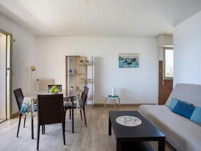 a table and chairs with a view of the beach at Apartment Les Voiliers by Interhome in Saint-Laurent-du-Var