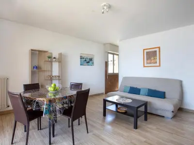 a bedroom with a white bed with two blue pillows at Apartment Les Voiliers by Interhome in Saint-Laurent-du-Var