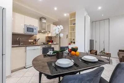 a kitchen and living room with a table and chairs at FEEL HOME - Congrès 13 in Nice