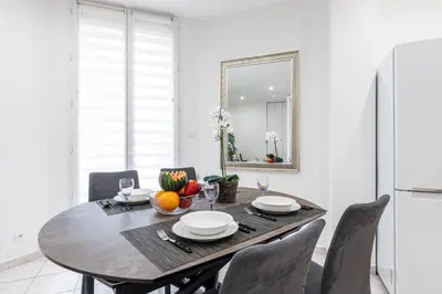 a dining room with a table and a mirror at FEEL HOME - Congrès 13 in Nice