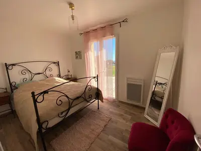a bedroom with a bed and a mirror and a chair at Villa Flora in La Gaude