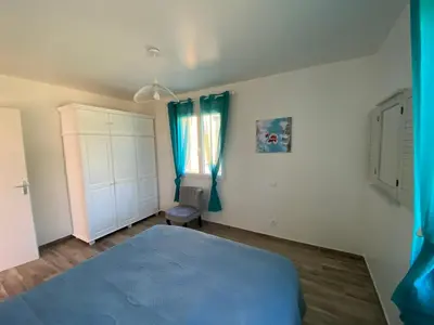 a bedroom with a blue bed and a window at Villa Flora in La Gaude